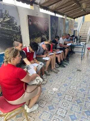 a group of people sitting on benches reading at Bait Alaqaba dive center & resort in Aqaba