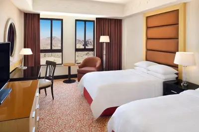 a hotel room with two beds and a television at Petra Marriott Hotel in Wadi Musa