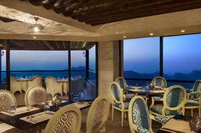 a restaurant with tables and chairs with a view at Petra Marriott Hotel in Wadi Musa