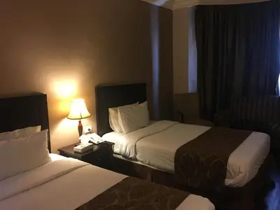 a hotel room with two beds and a lamp at Shepherd Hotel in Amman