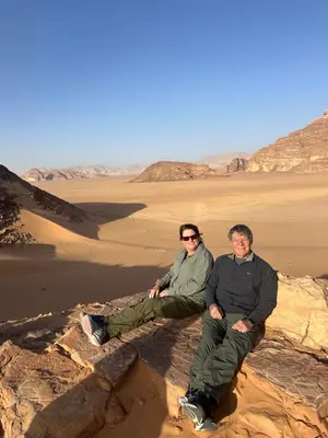 two men sitting on a rock in the desert at Bubbles Desert Camp Jeep Tours in Wadi Rum