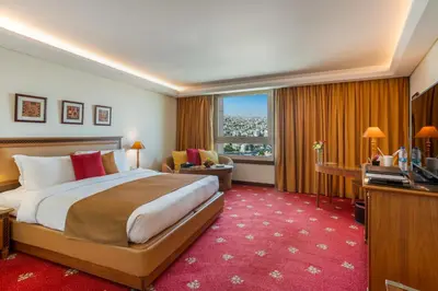 a hotel room with a bed and a television at Le Royal Hotel - Amman in Amman