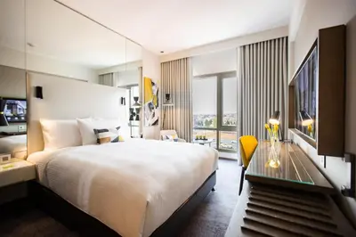 a hotel room with a large bed and a desk at Centro Mada Amman by Rotana in Amman