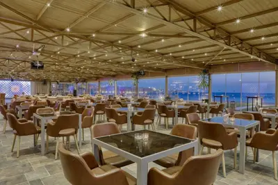 a banquet hall with tables and chairs and windows at Grand Tala Bay Resort, Aqaba in Aqaba