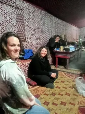 two women sitting on the floor in a living room at Shahrazad desert, Wadi Rum in Wadi Rum