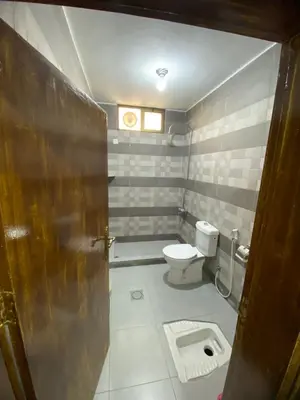 a small bathroom with a toilet and a door at Omar Apartment in Wadi Musa