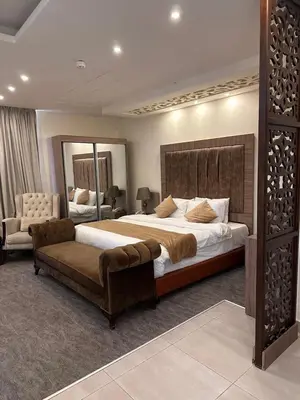a large bedroom with a large bed and a couch at AlQimah Hotel Apartments in Amman