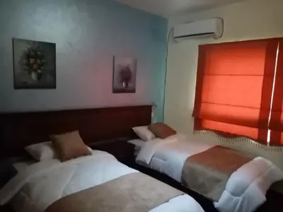 a hotel room with two beds and a window at الفارس الوسيم للشقق الفندقيه in Amman