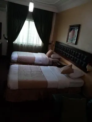 two beds in a hotel room with a window at الفارس الوسيم للشقق الفندقيه in Amman