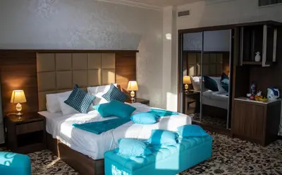 a bedroom with a large bed with blue pillows at The Castle Hotel in Amman
