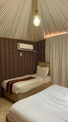 a room with two beds in a tent at Osama Luxury Camp for Camping and Bubbles in Wadi Rum
