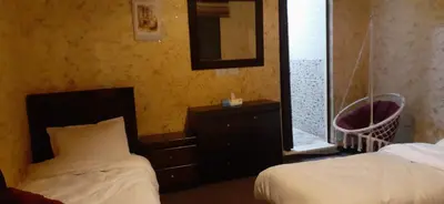 a bedroom with a bed and a dresser and a mirror at Petra bedouin house in Al Ḩayy