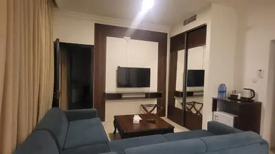 a living room with a blue couch and a tv at Jordan View Hotel in Amman