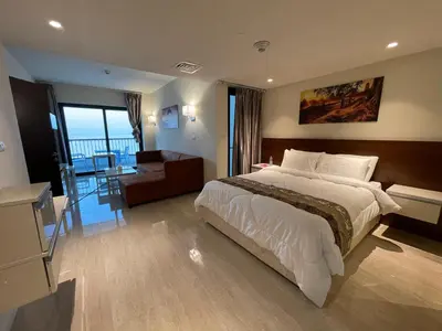 a bedroom with a large bed and a living room at Porto dead sea in Sowayma