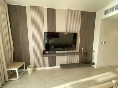 a living room with a television on a wall at Porto dead sea in Sowayma