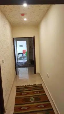 a hallway with a room with a mirror and a rug at Petra Stones Inn in Wadi Musa