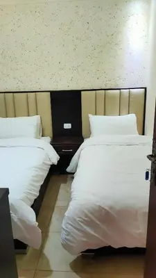 a room with two beds and a laptop on a table at Petra Stones Inn in Wadi Musa