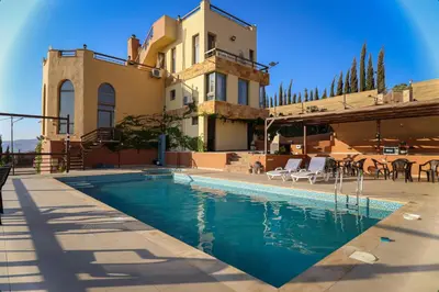 a swimming pool in front of a house at Sultana Farm - Private Pool Villa near Amman in Bayyūḑah