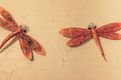 three orange butterflies are hanging on a wall at The Precious Villa in Sowayma