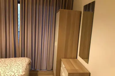 a bedroom with a bed and a dresser next to a window at My Cosy little place in Amman