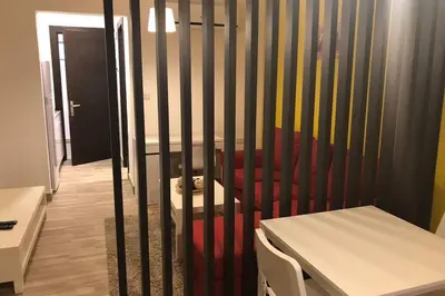 a crib in a room with a red couch and a table at My Cosy little place in Amman
