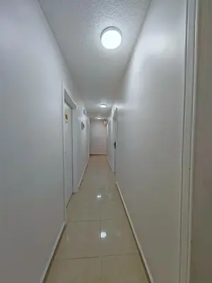 a long hallway with a white wall and a ceiling at Cleopetra Hotel in Wadi Musa