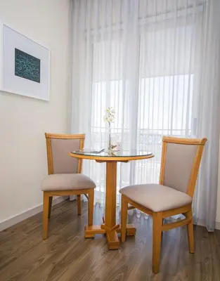 a dining room table with two chairs and a table with a vase at AlQasr Metropole Hotel in Amman