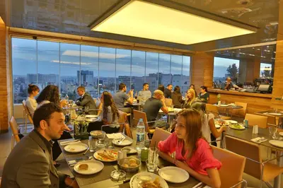 a group of people sitting at tables in a restaurant at AlQasr Metropole Hotel in Amman