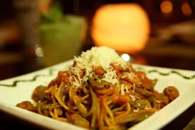 a plate of spaghetti with cheese on top of it at AlQasr Metropole Hotel in Amman
