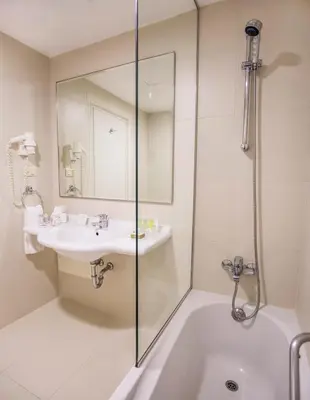 a bathroom with a tub and a sink and a shower at AlQasr Metropole Hotel in Amman