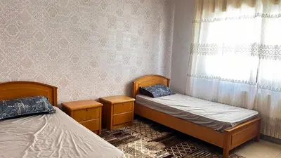 two beds in a room with a window at Eva house Lovely 3 bedrooms unit in great location in Amman for families in Amman