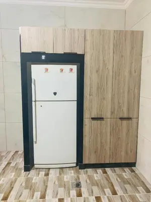 a white refrigerator in a kitchen next to a cabinet at Eva house Lovely 3 bedrooms unit in great location in Amman for families in Amman