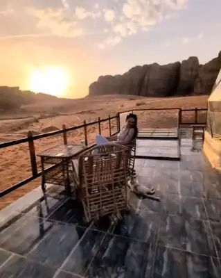 a woman sitting in a chair looking out at the desert at orbit camp 2 in Wadi Rum