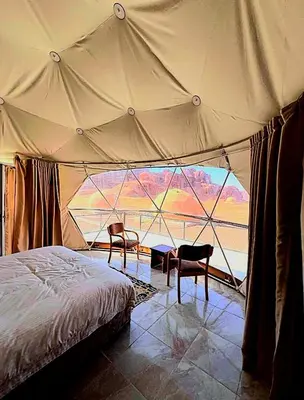 a bedroom with a tent with two chairs and a bed at Lukasa camp Wadi Rum in Wadi Rum