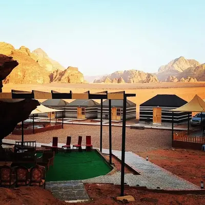 a golf course in the middle of a desert with mountains at Lukasa camp Wadi Rum in Wadi Rum