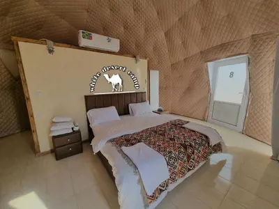a bedroom with a bed with a sign on the wall at White Desert Camp in Wadi Rum