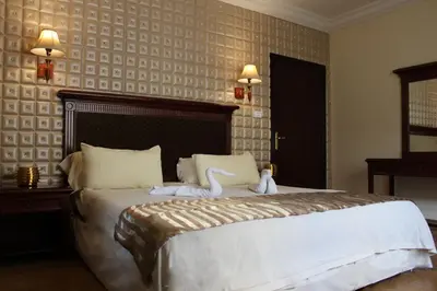 a bedroom with a bed with two swans on it at Rana Palace in Amman