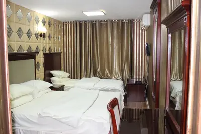 a hotel room with two beds and a television at Rana Palace in Amman