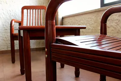 two wooden chairs and a bed in a room at Rana Palace in Amman