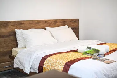 a bedroom with two beds with white sheets at Hikaya studios in Wadi Musa
