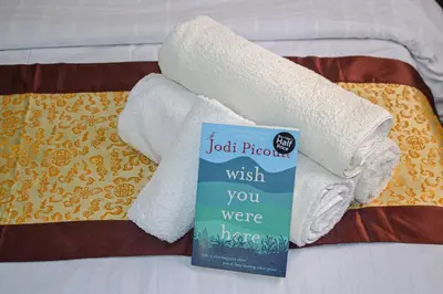 a book sitting on top of a bed with towels at Hikaya studios in Wadi Musa