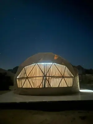 a glass dome is lit up at night at Rum Rayan magic camp in Wadi Rum