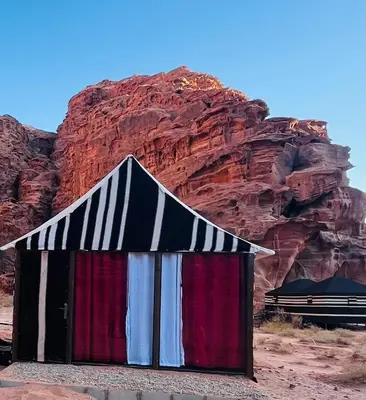 a small building in the desert next to a mountain at moon city with jeep trips in Wadi Rum