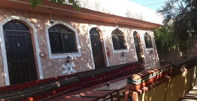 a building with a wooden bench in front of it at Petra Bedouin House 1 Attallah guest house in Wadi Musa