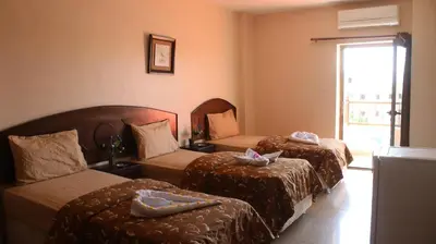 a hotel room with two beds and a couch at Baraka Al Aqaba Hotel Suites in Aqaba