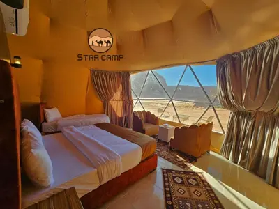 a bedroom with two beds and a view of the desert at Star Camp in Wadi Rum