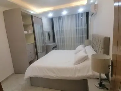 a bedroom with a white bed and a mirror at Executive Apartments in Amman