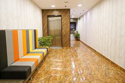 a lobby with a corridor with a couch and a door at flamingo hotel irbid in Zabdah