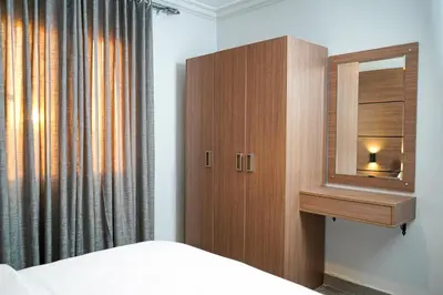 a bedroom with a wooden cabinet and a mirror at flamingo hotel irbid in Zabdah