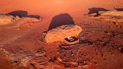 an aerial view of a desert with a road at Wadi Rum Cave Camping in Wadi Rum
